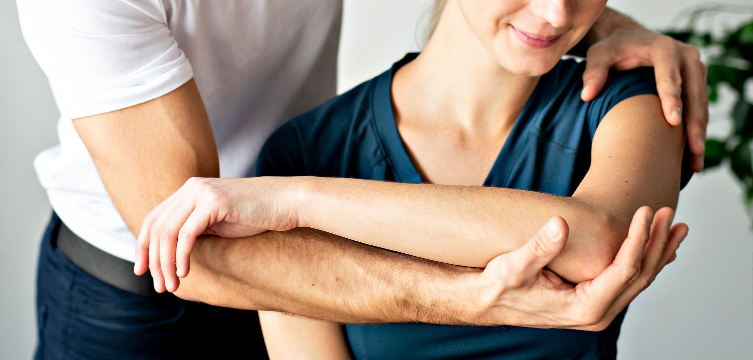 Physical therapist holding a woman's elbow